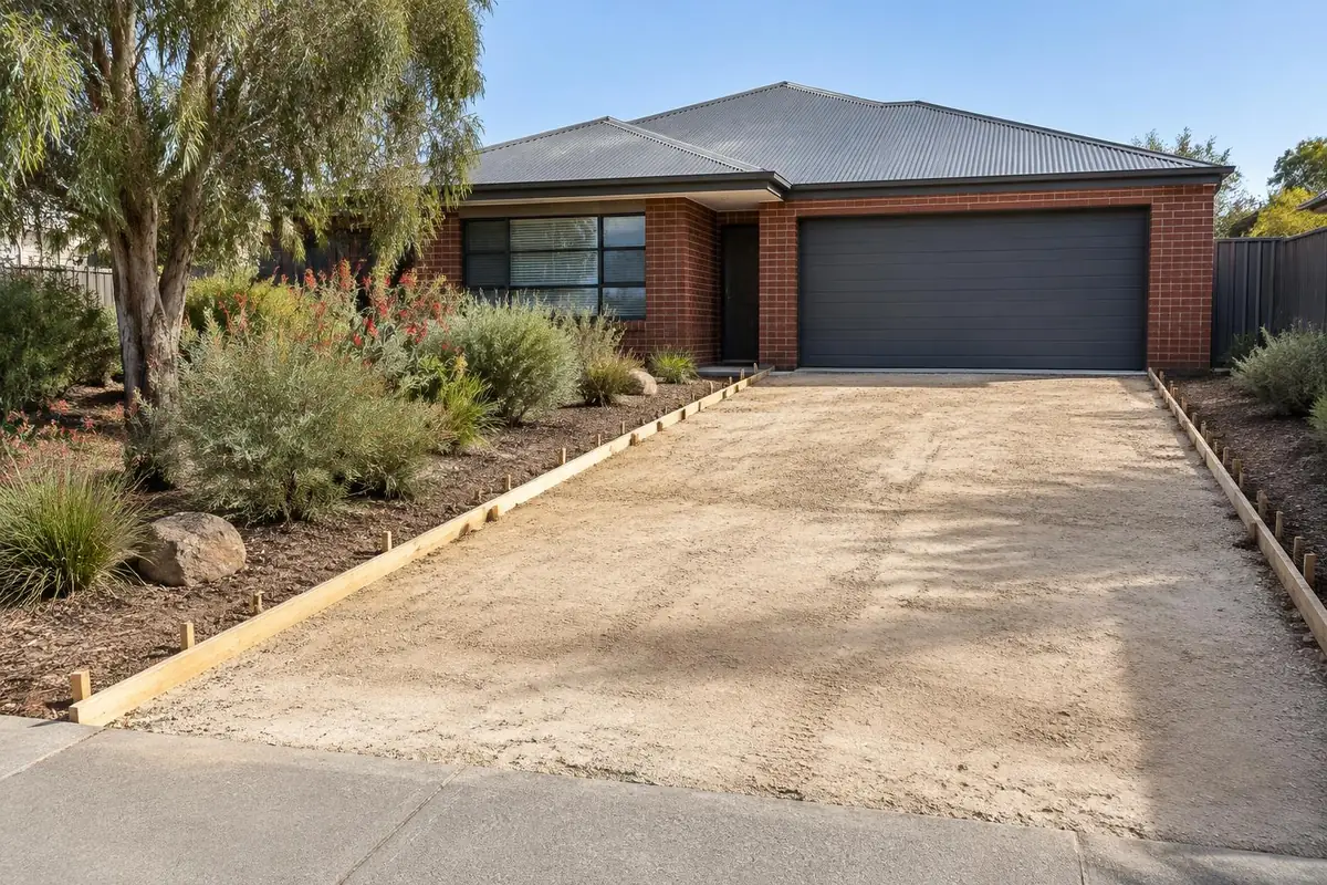 Illustrative image: driveway area at a brick Perth home with the old surface removed, a compacted sand base and timber formwork